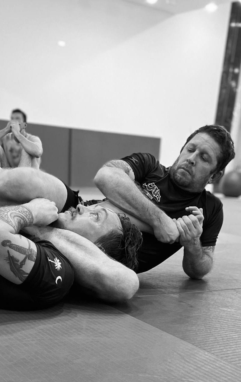 Two No-Gi athletes working an arm lock on the mats