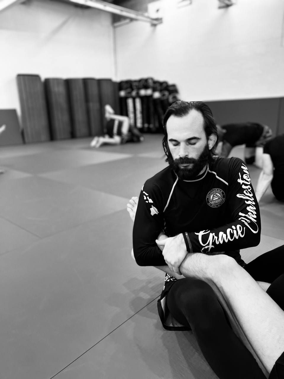 A coach walking a beginner through a position on the mats
